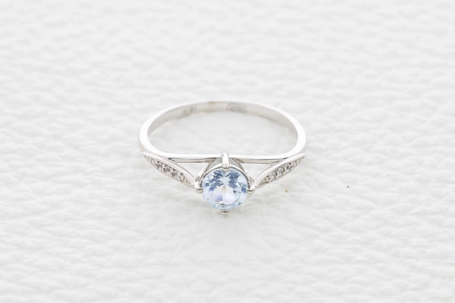 Кольцо из белого золота с топазом sky и 6 фианитами