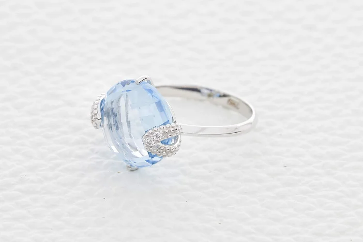 Кольцо из белого золота с топазом sky и 6 фианитами