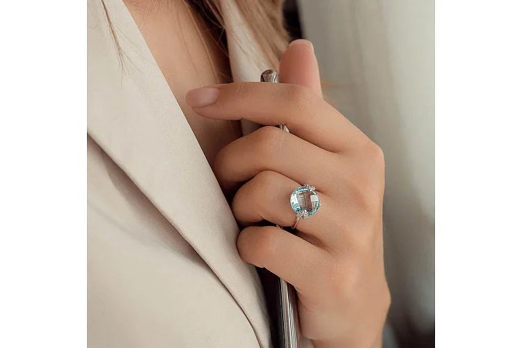 Кольцо из белого золота с топазом sky и 6 фианитами