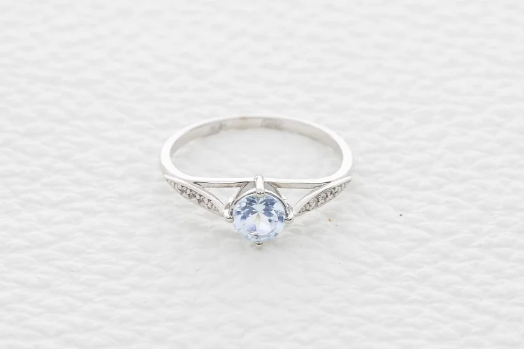 Кольцо из белого золота с топазом sky и 6 фианитами