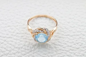 Кольцо из красного золота с топазом sky и 16 фианитами