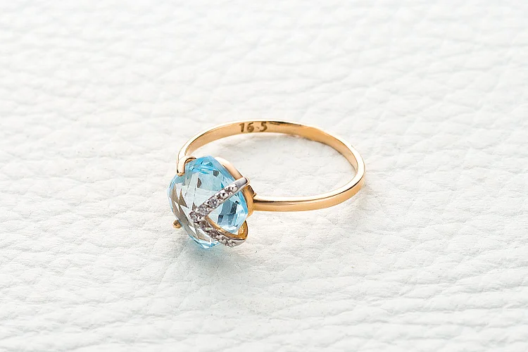 Кольцо из красного золота с топазом sky и 5 фианитами