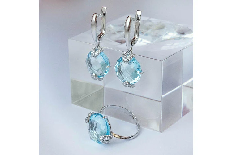 Кольцо из белого золота с топазом sky и 6 фианитами