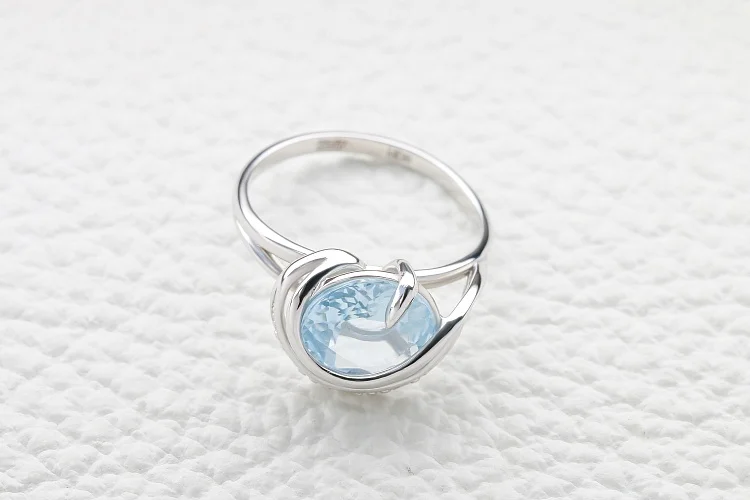 Кольцо из белого золота с топазом sky и 3 фианитами