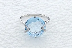 Кольцо из белого золота с топазом sky и 10 фианитами