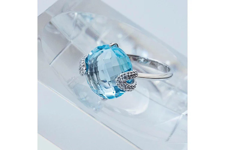 Кольцо из белого золота с топазом sky и 6 фианитами