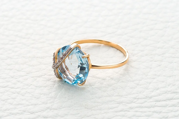 Кольцо из красного золота с топазом sky и 16 фианитами