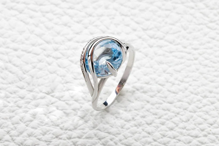 Кольцо из белого золота с топазом sky и 3 фианитами